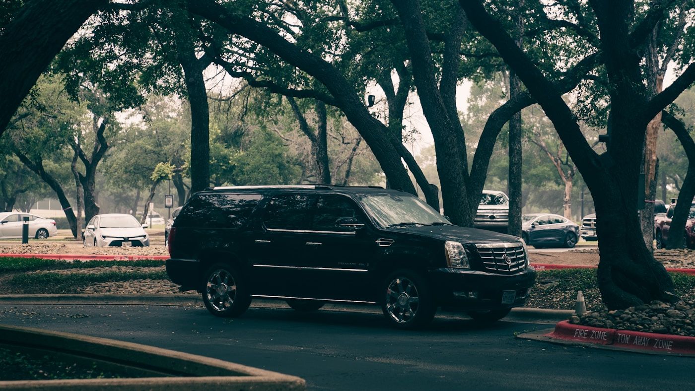 Black luxury SUV with dark ceramic tinted windows all around, parked outdoors